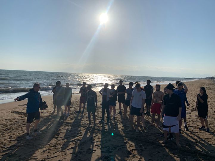 en gruppe mennesker som står på en strand