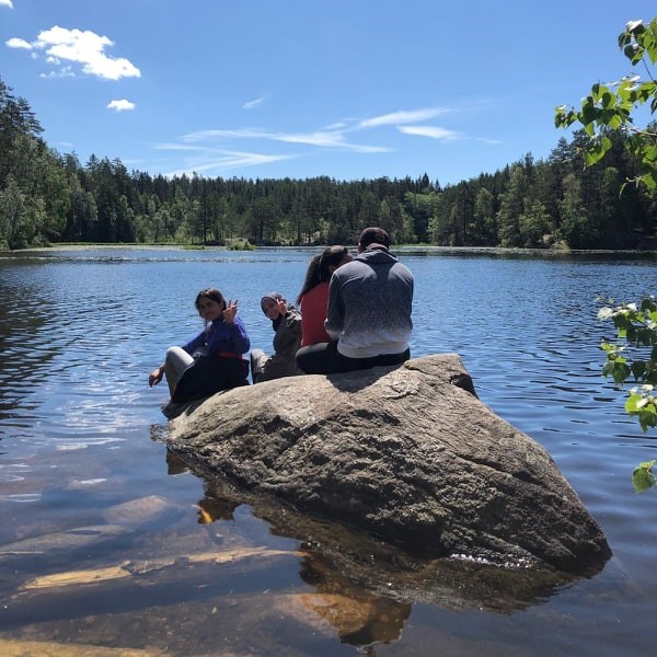 Elever sitter på stein i vann