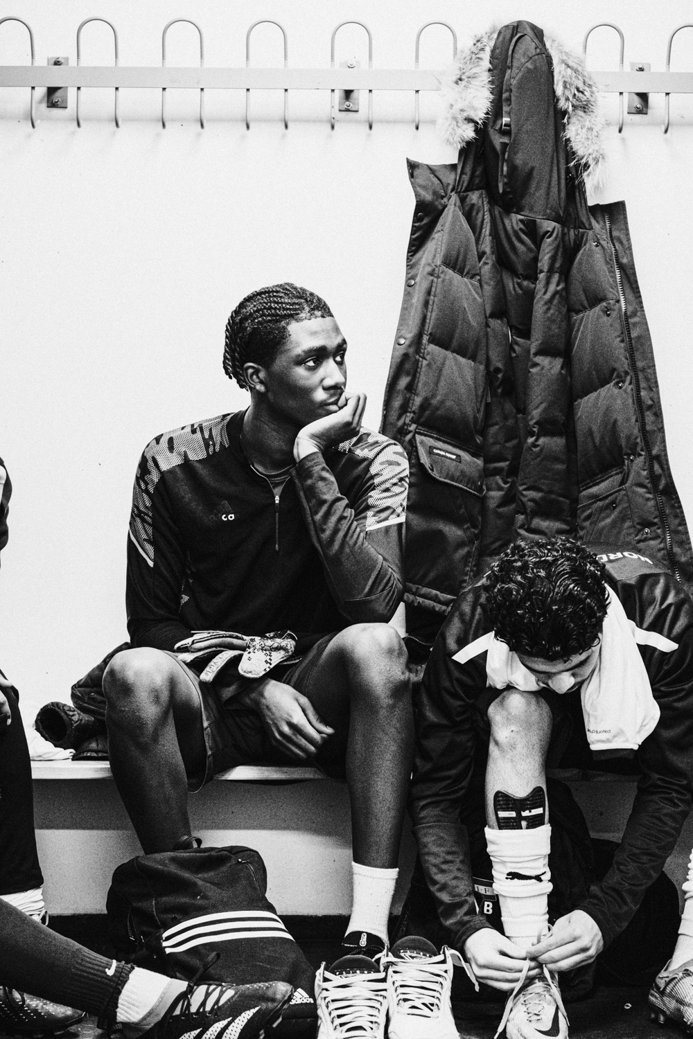 en person som sitter på en benk med en annen person stående bak seg