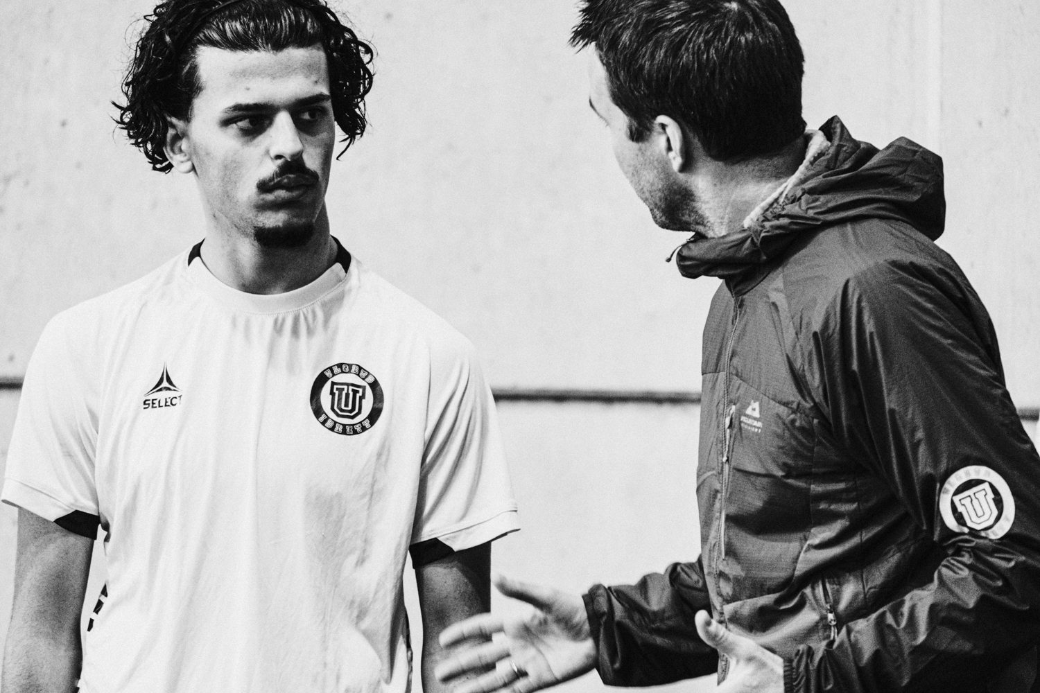 a man with his hand on another man's shoulder