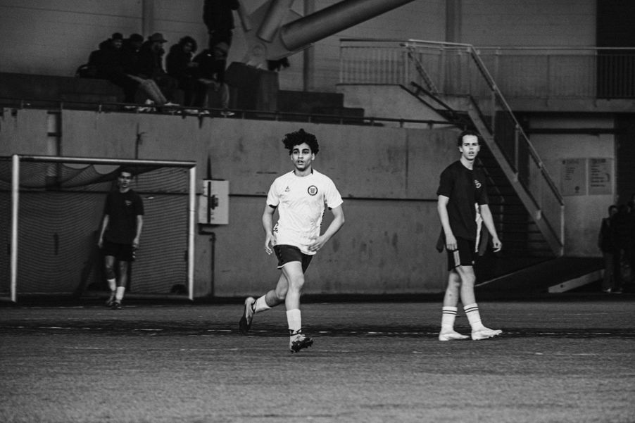 en person i uniform som løper på et jorde