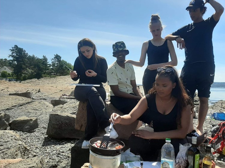 Elever lager mat ved sjøen