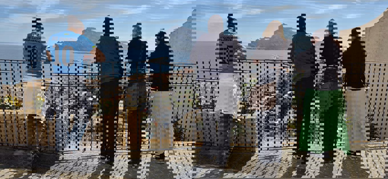 En gruppe mennesker som står på en bro over vann