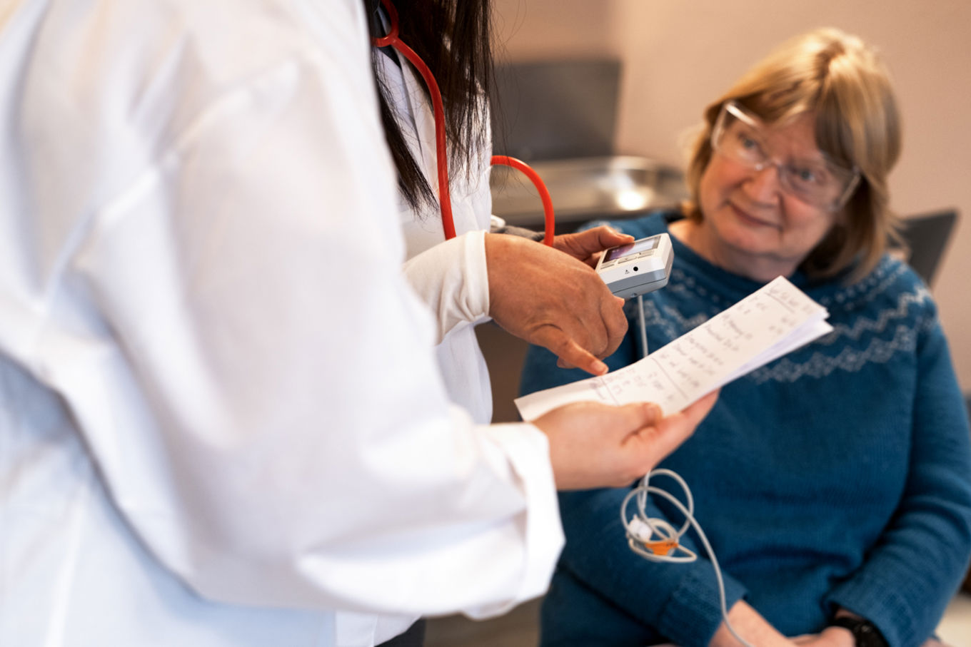 en lege som viser en pasient noe på papiret en lege som viser en pasient noe på papiret